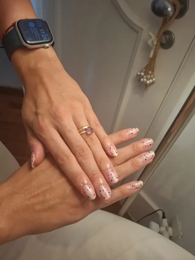 Nail art com confete colorido sobre base nude, trabalho real do Espaço Maura Cunha